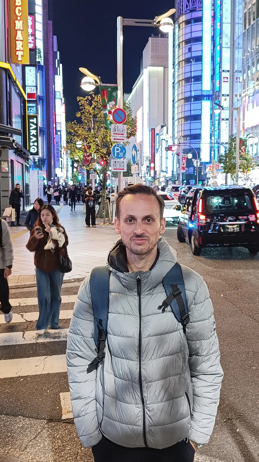 Bruno Oliveira numa rua iluminada no Japão.